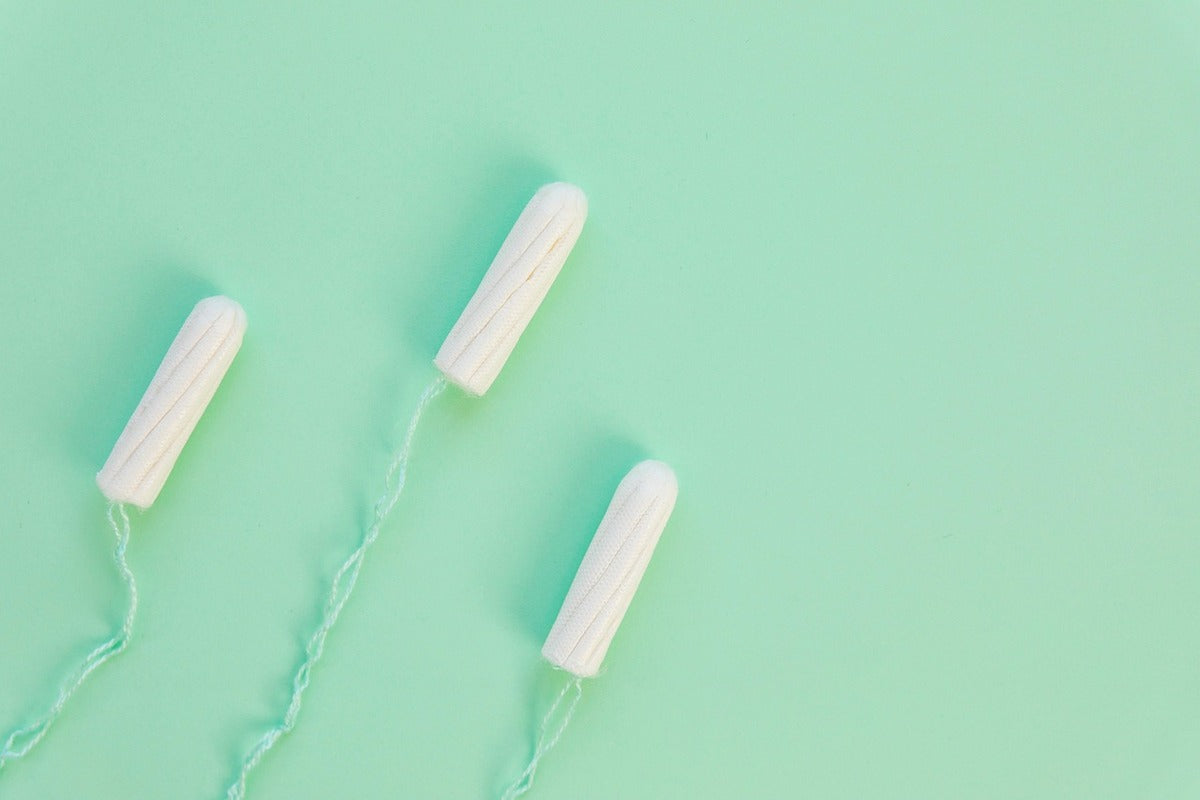 tampons with mint green string against matching background