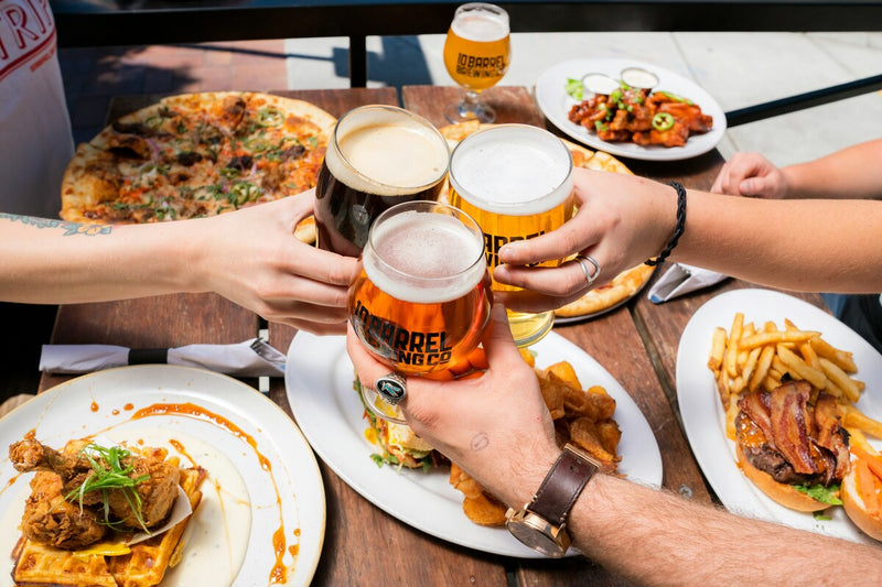 group clinking drinks together over a meal