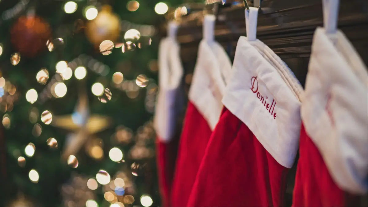 Stocking filler - stockings lined up on fireplace adjacent to Christmas tree