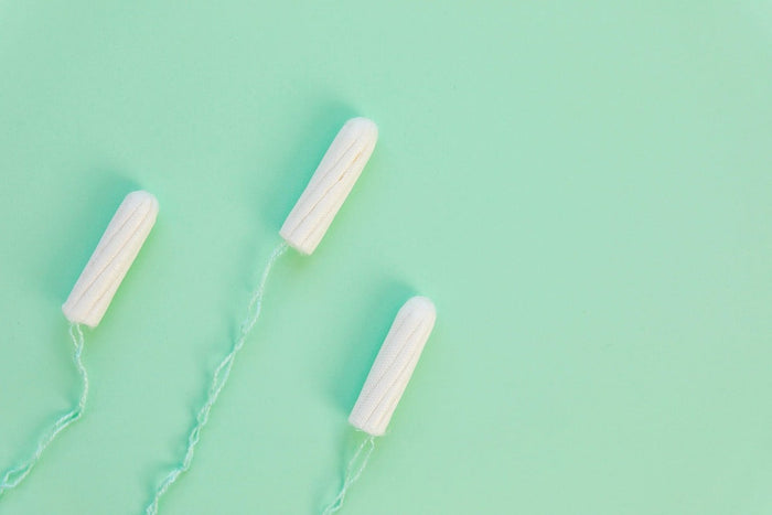 tampons with mint green string against matching background