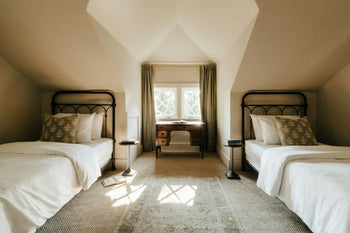 two beige coloured separate beds at either side of a room