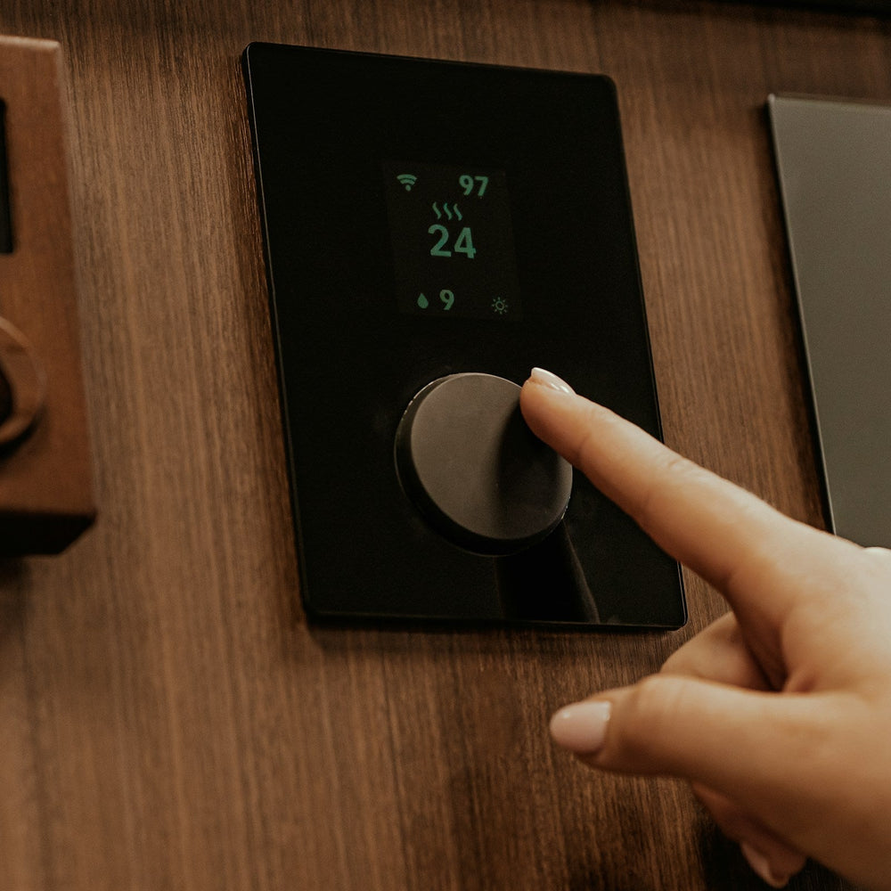 finger reaching out to adjust thermostat