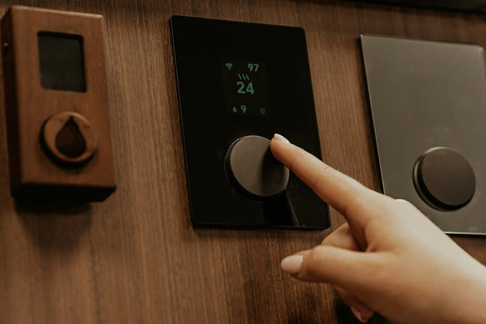 finger reaching out to adjust thermostat