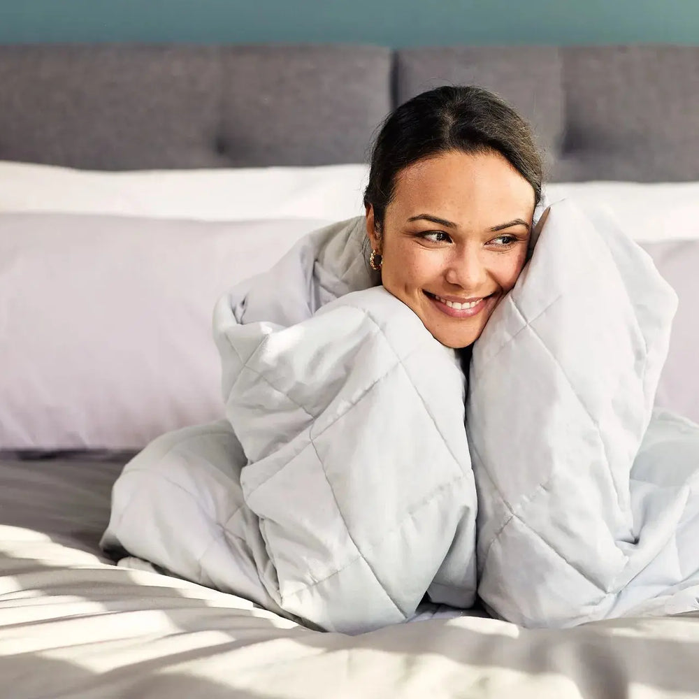 Woman in bed wrapped in Emma Hug Weighted Blanke