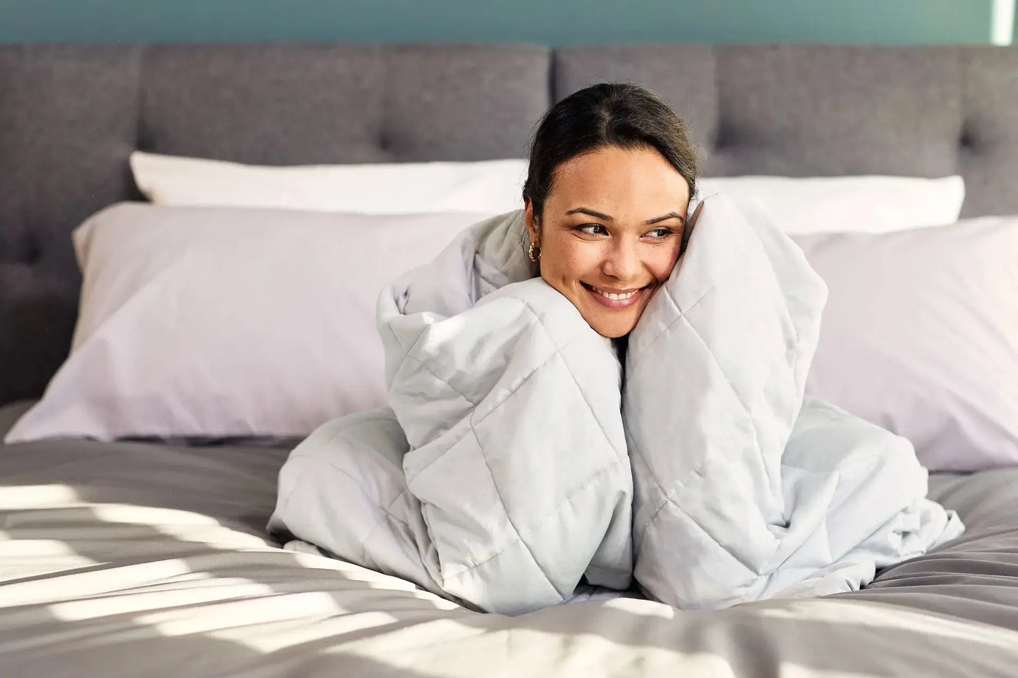 Woman in bed wrapped in Emma Hug Weighted Blanke