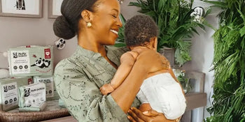 Woman holding her baby next to Mama Bamboo nappy products
