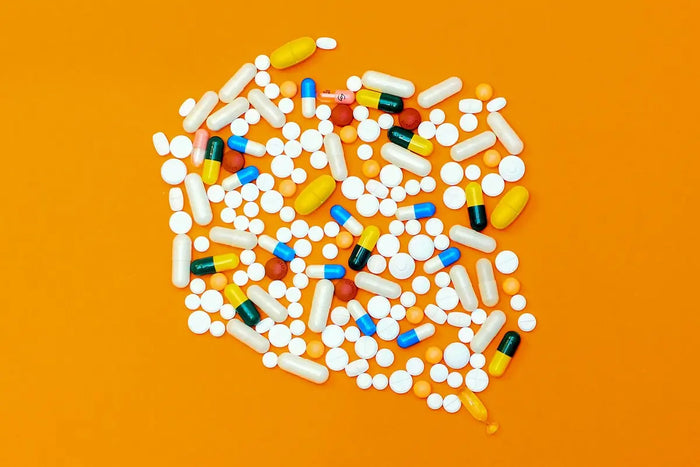 a scattering of vitamin pills against an orange background