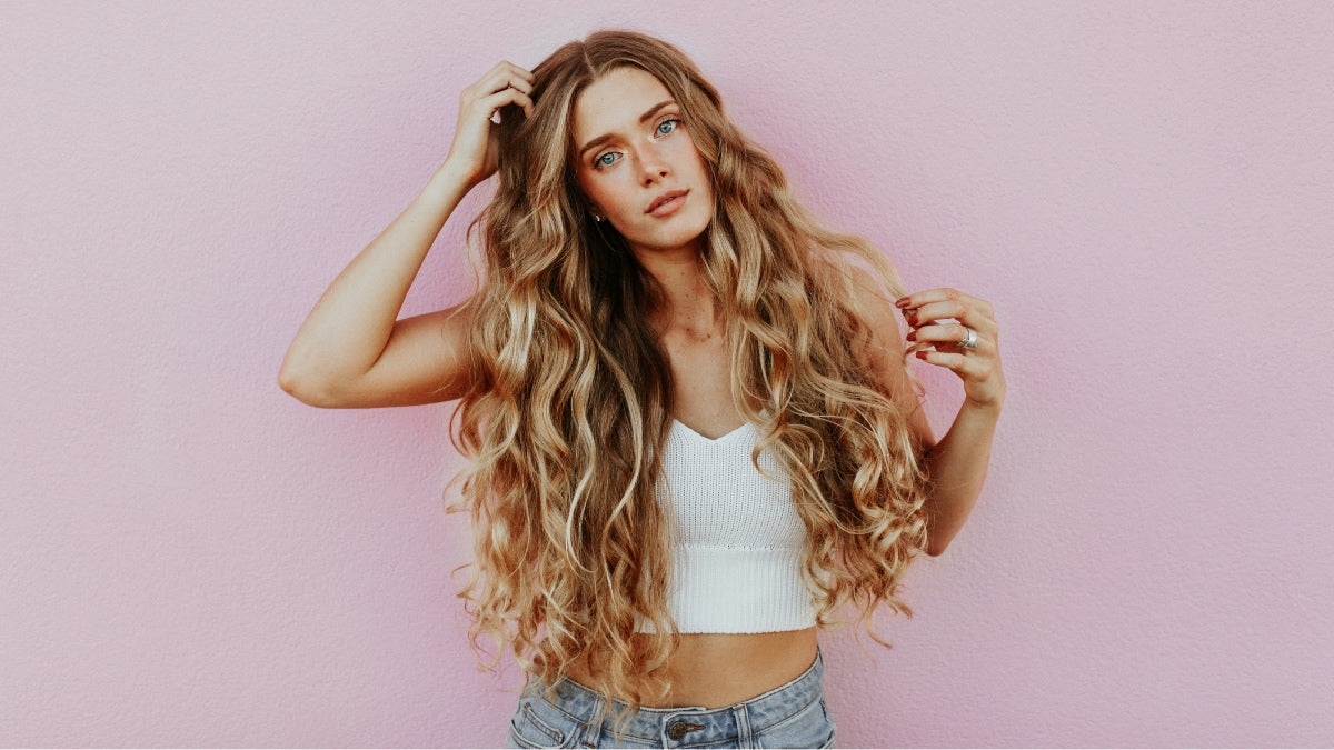 Woman with long blonde curly hair and tanned skin