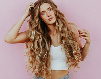 Woman with long blonde curly hair and tanned skin